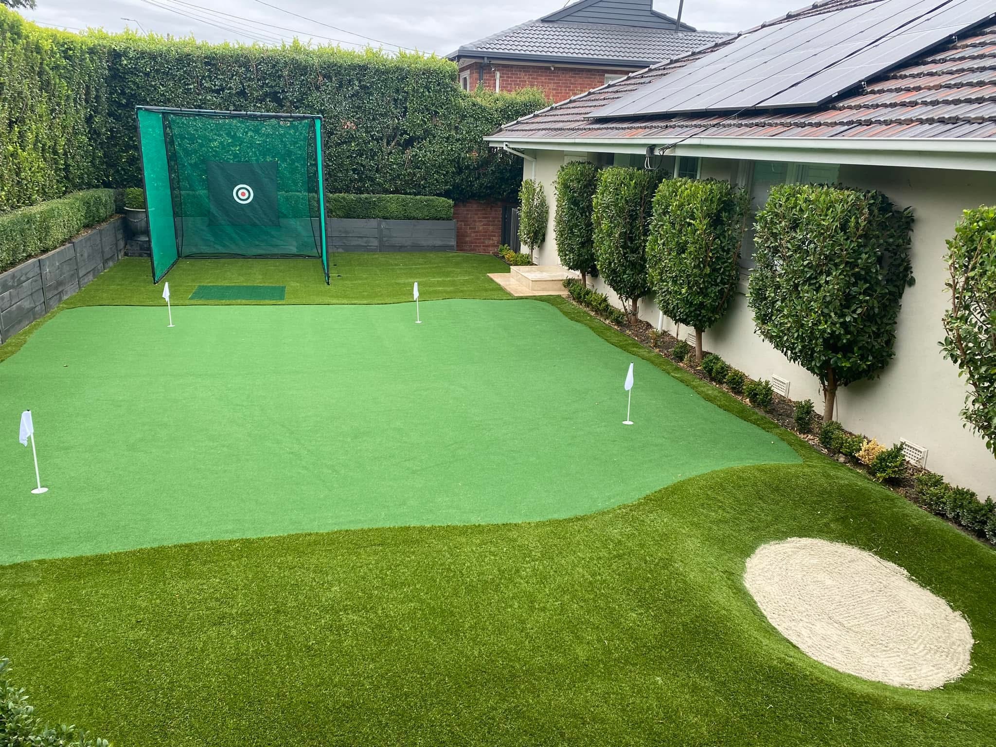 Backyard golf setup with chipping net and sand bunker