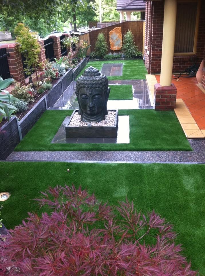 Landscaped courtyard with synthetic grass and Buddha feature