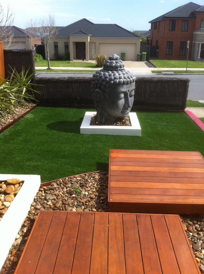 Front yard with synthetic grass, Buddha statue and timber deck