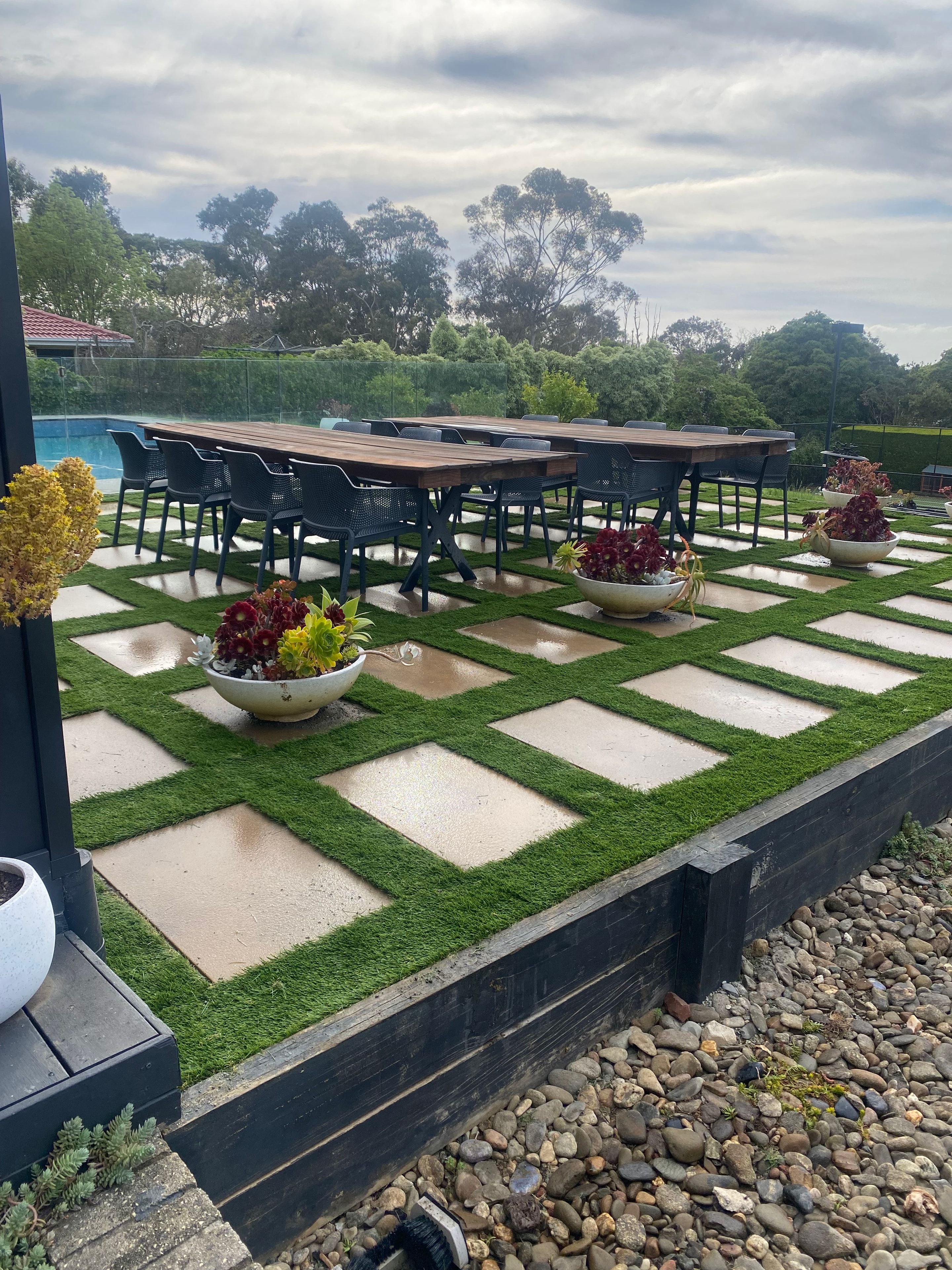 Residential garden with geometric paving and synthetic grass